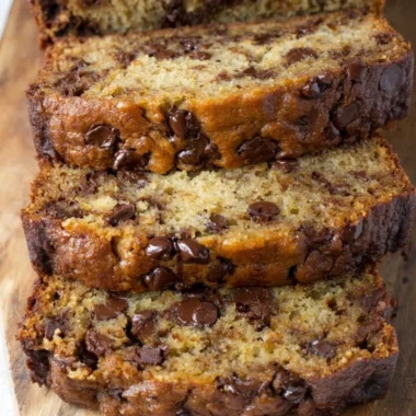 Moist and delicious chocolate chip banana bread sliced on a wooden cutting board.