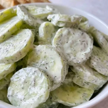 Fresh creamy cucumber salad with a rich dressing served in a bowl.