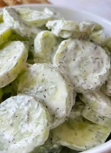 Fresh creamy cucumber salad with a rich dressing served in a bowl.