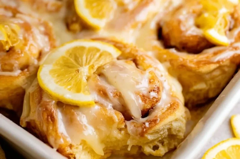 Freshly baked lemon rolls drizzled with icing sugar, ready to be served.