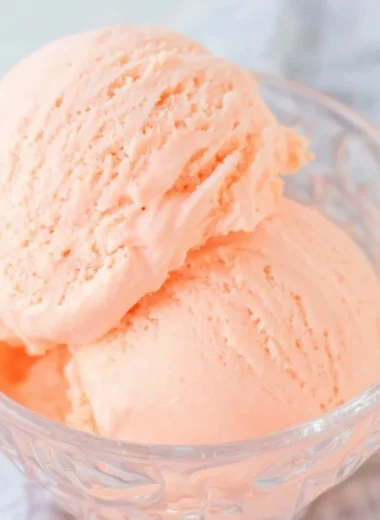 Delicious Ninja Creami orange ice cream in a bowl decorated with orange slices.