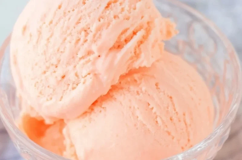 Delicious Ninja Creami orange ice cream in a bowl decorated with orange slices.