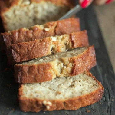 Moist sour cream banana bread served on a wooden cutting board