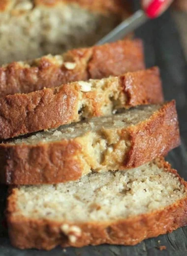 Moist sour cream banana bread served on a wooden cutting board