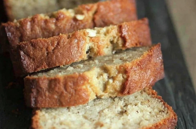 Moist sour cream banana bread served on a wooden cutting board