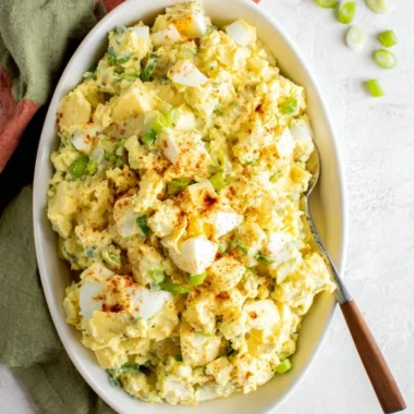 Southern potato salad with creamy dressing and garnished with herbs