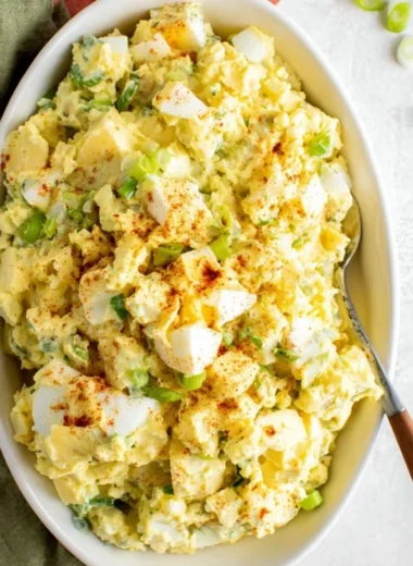 Southern potato salad with creamy dressing and garnished with herbs