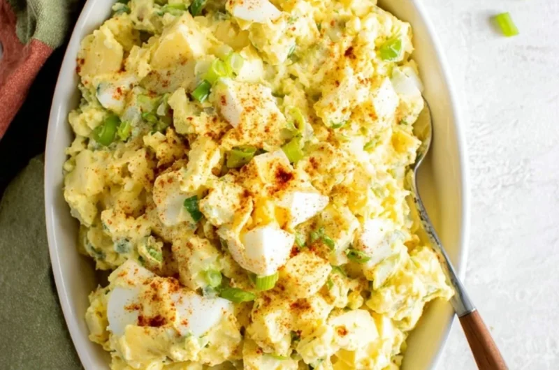 Southern potato salad with creamy dressing and garnished with herbs