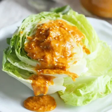 Bowl of homemade Carrot Ginger Dressing with fresh ingredients and vibrant color