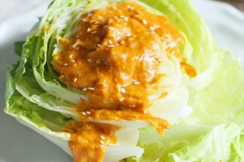 Bowl of homemade Carrot Ginger Dressing with fresh ingredients and vibrant color
