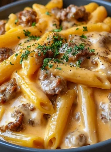 Creamy beef pasta dish served in a bowl with parsley garnish.