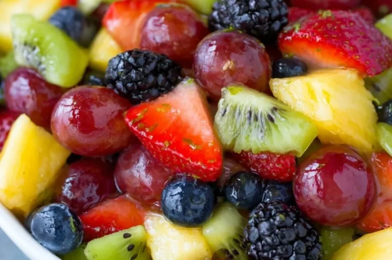 Vibrant fruit salad with honey lime dressing and mixed berries for a refreshing treat.