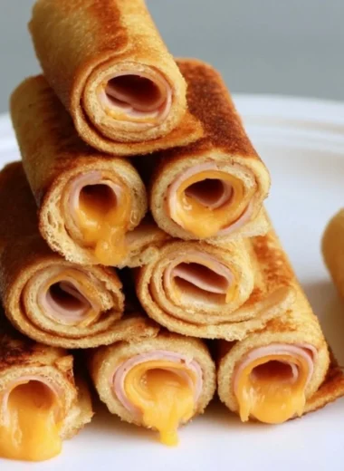 Cheesy grilled cheese roll-ups served on a plate with dipping sauce