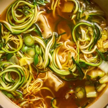 A steaming bowl of Gyoza Soup with dumplings in a savory broth