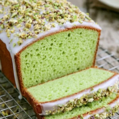 Homemade pistachio loaf with nuts on a wooden cutting board