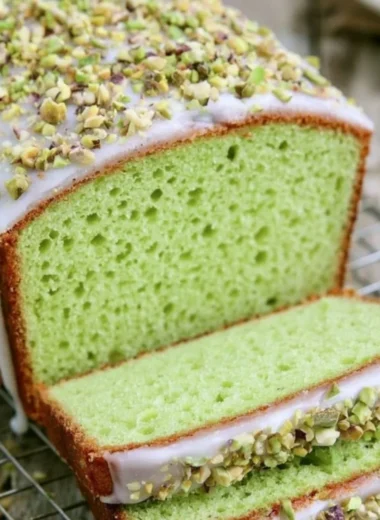 Homemade pistachio loaf with nuts on a wooden cutting board