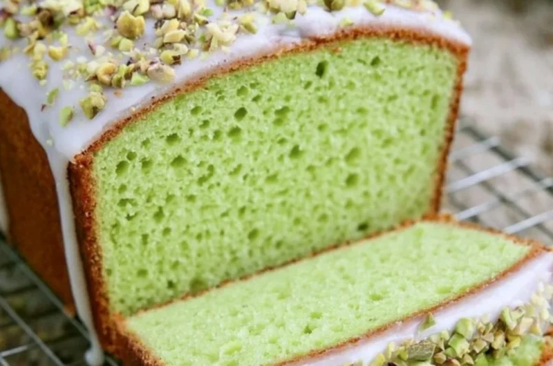 Homemade pistachio loaf with nuts on a wooden cutting board