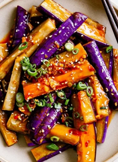 Spicy eggplant stir fry with vibrant vegetables and herbs in a skillet