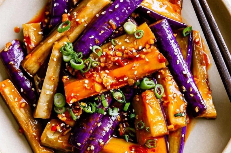 Spicy eggplant stir fry with vibrant vegetables and herbs in a skillet