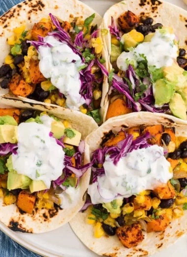 Sweet potato and black bean tacos topped with avocado and cilantro