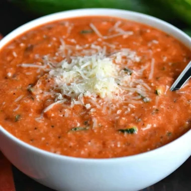 Bowl of delicious zucchini tomato soup garnished with fresh herbs