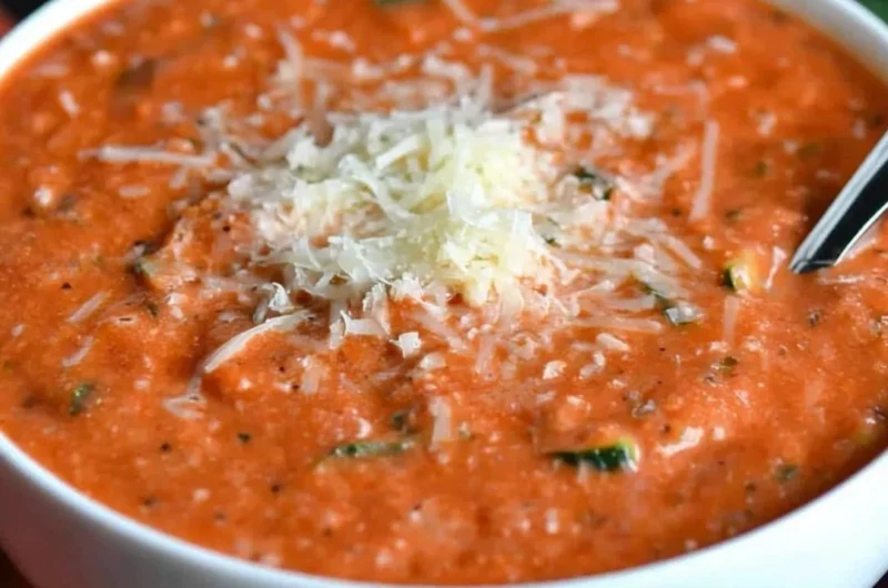 Bowl of delicious zucchini tomato soup garnished with fresh herbs