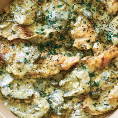 Delicious Chicken Piccata with Artichokes served on a white plate.