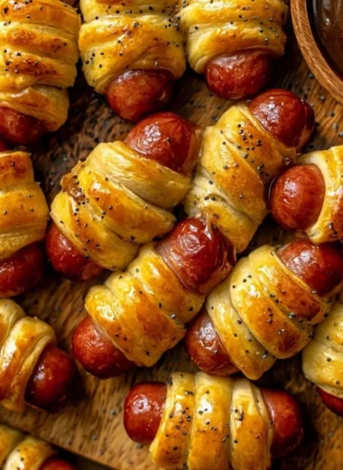 Delicious glazed pigs in a blanket served on a platter with dipping sauce