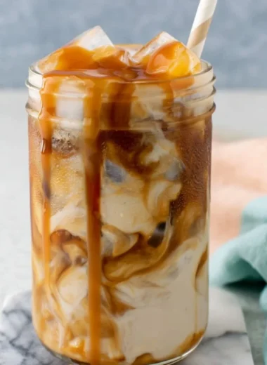 Glass of homemade caramel iced coffee with a drizzle of caramel on top.