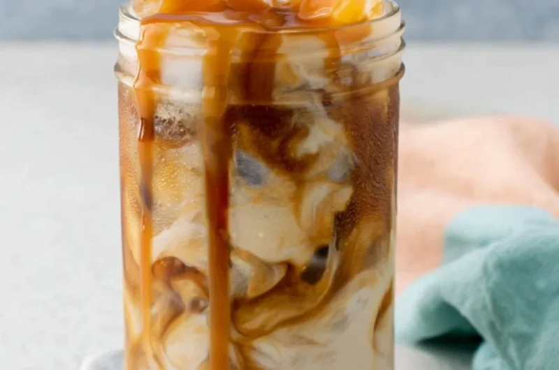 Glass of homemade caramel iced coffee with a drizzle of caramel on top.
