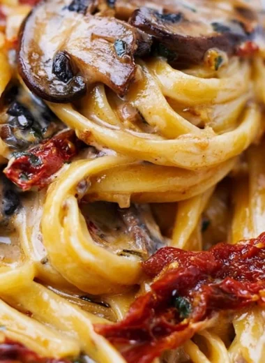 Sun-Dried Tomato Mushroom Pasta served in a bowl topped with herbs
