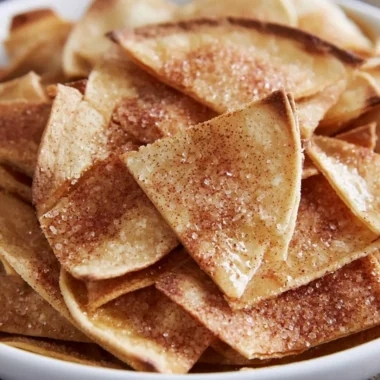 Cinnamon sugar tortilla chips stacked on a plate, ready to enjoy.